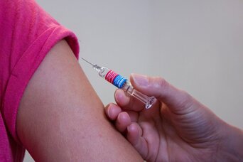 Impfung im Arm mit einer Spritze